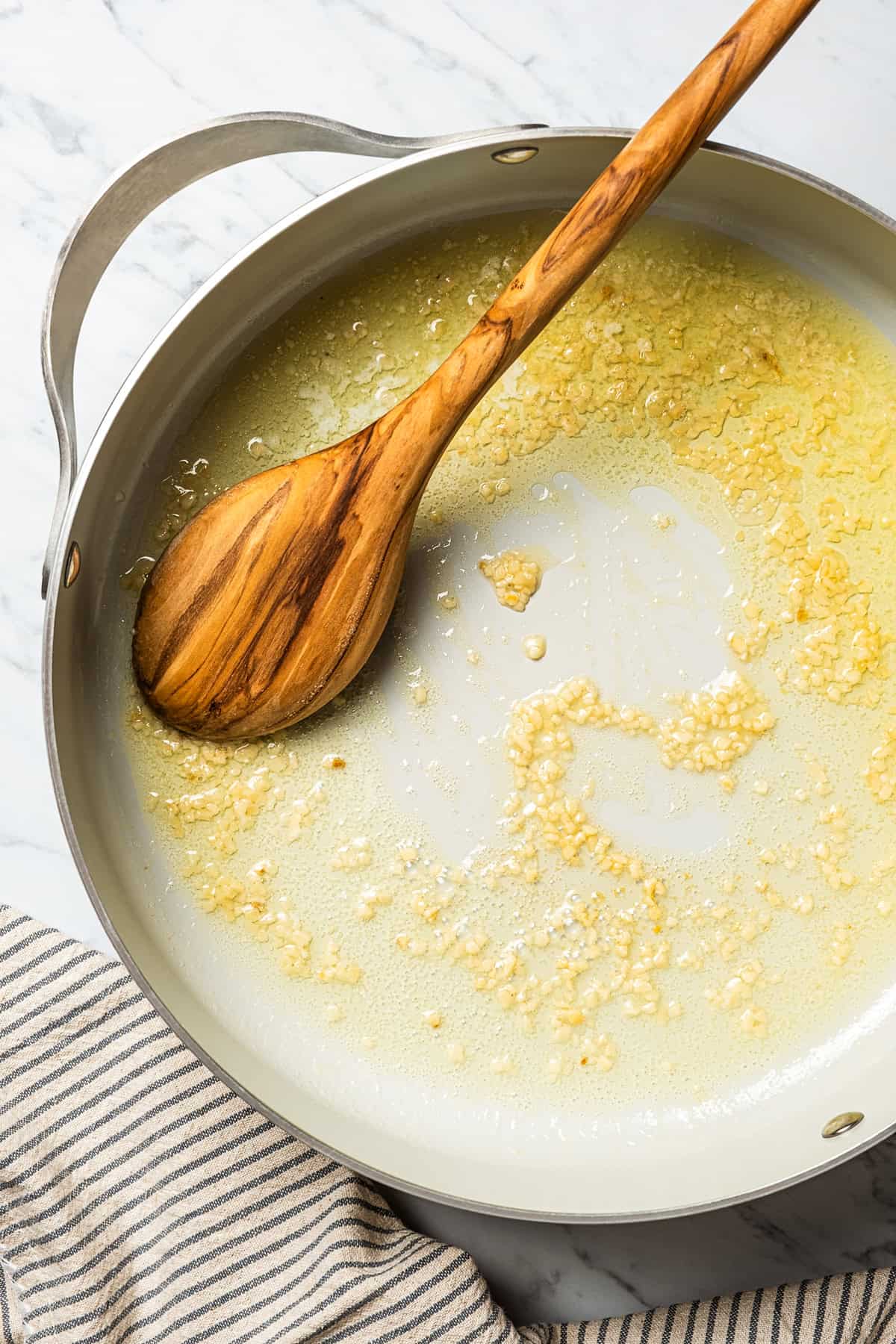 Sauteing minced garlic in a skillet.