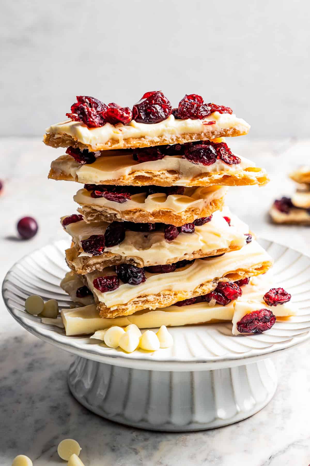 Christmas crack stacked on a small white cake stand.