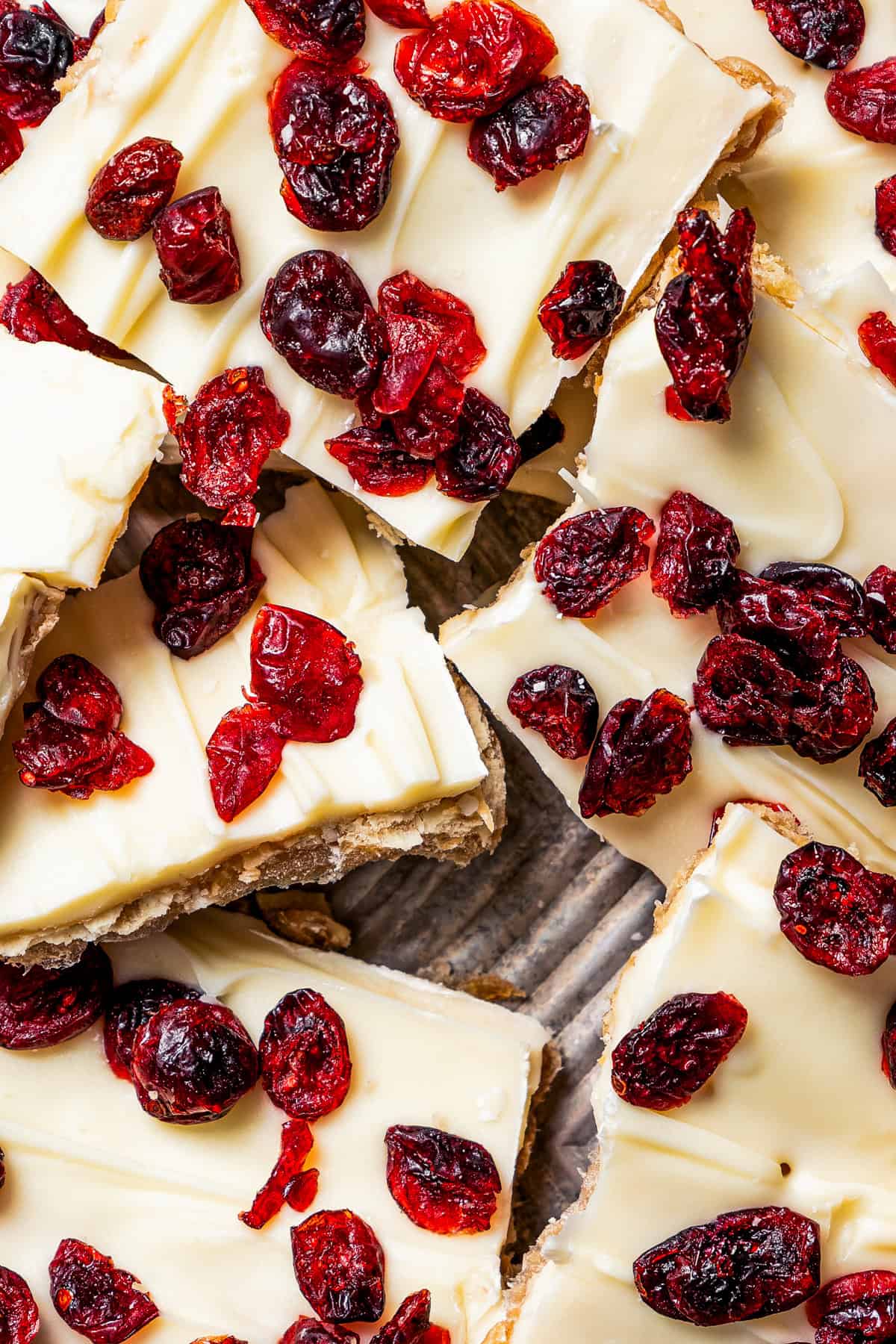 Broken up pieces of Christmas crack topped with cranberries.