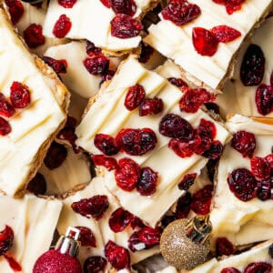 Overhead view of Christmas crack scattered on a sheet pan with small red and green Christmas ball ornaments.