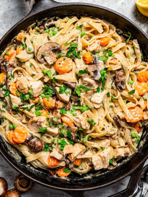 Overhead image of a cast iron skillet filled with pasta and turkey chunks in a creamy sauce to make turkey tetrazzini.