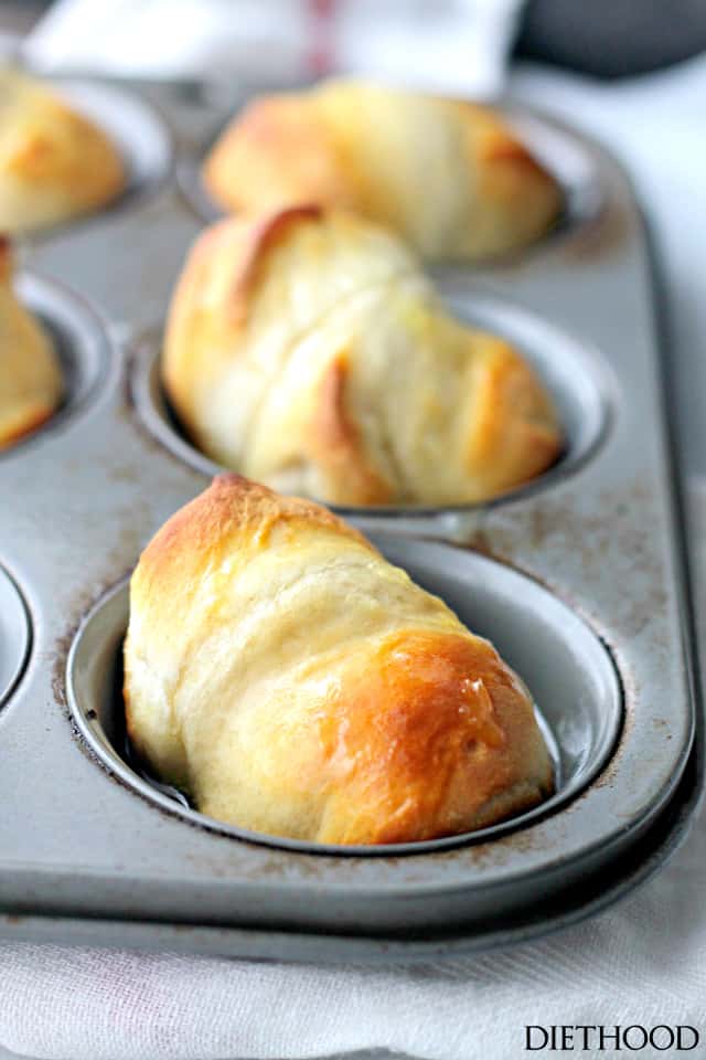 Freshly baked, sweet golden dinner rolls in a muffin tray