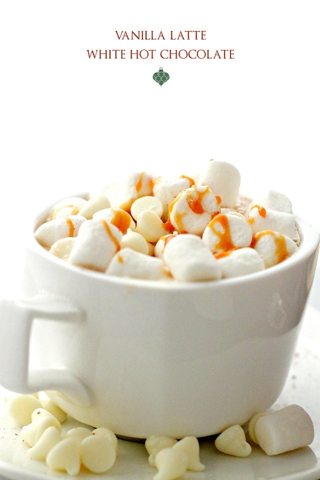 Side view of Vanilla Latte White Hot Chocolate in a mug topped with marshmallows, white chocolate chips and caramel drizzle