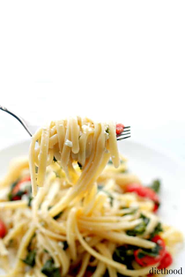 Fork pulling up fettuccine pasta.