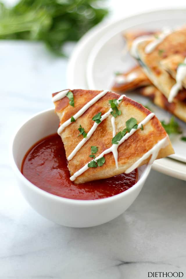 Dipping a pizza quesadilla in marinara sauce