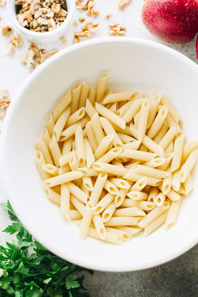 Cooked penne pasta in a salad bowl.