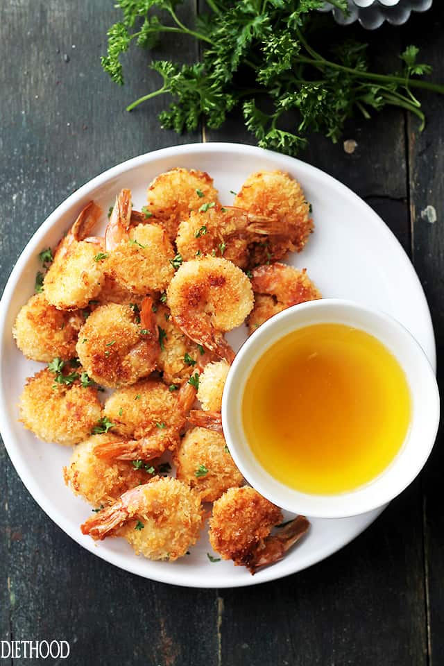 Plate of baked battered shrimp with garlic dipping sauce. 