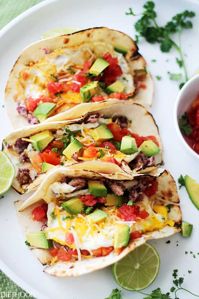 Tacos stuffed with eggs, cheese, tomatoes, refried beans, and avocados.