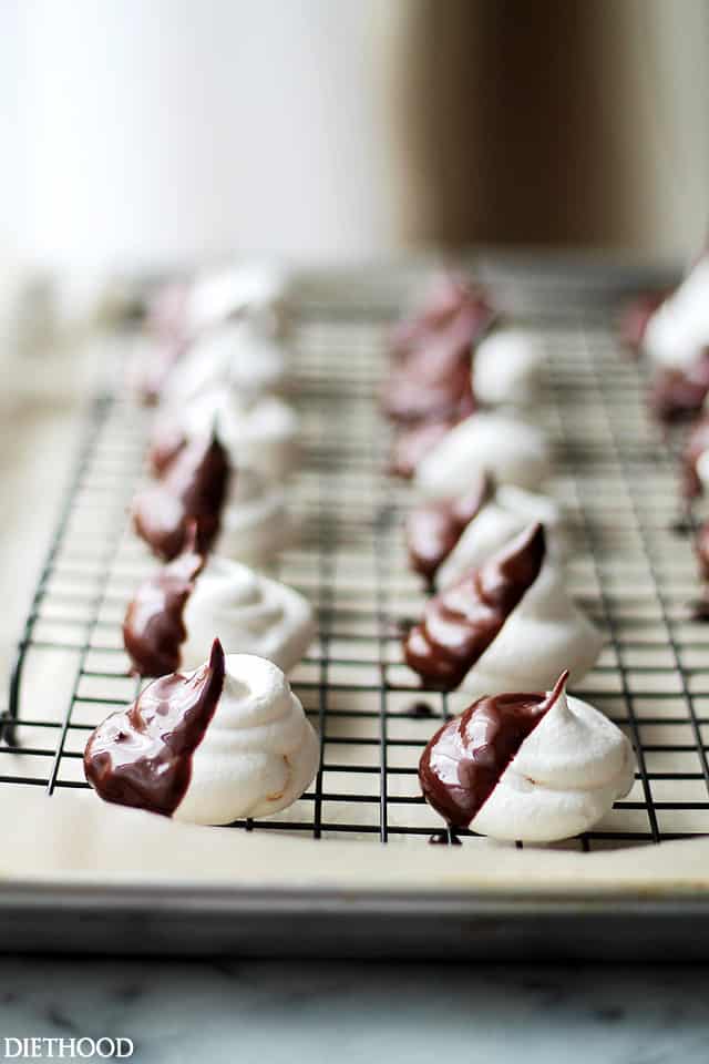 Closeup of black and white meringue cookies on a wire cooling wrack.