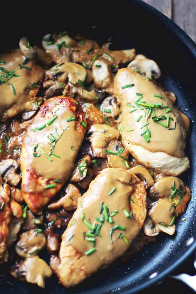 Cooking chicken breasts in a skillet to make dijon chicken with mushrooms.