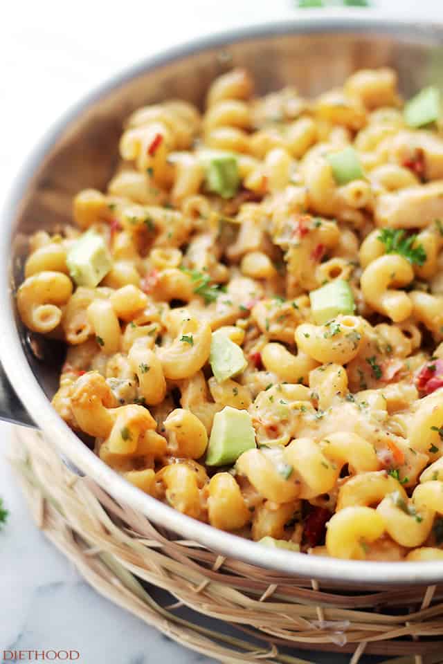 Close up of a frying pan filled with spicy chicken, vegetables, homemade alfredo sauce and cavatappi pasta