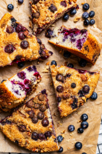 Slices of blueberry cake arranged on brown parchment paper.