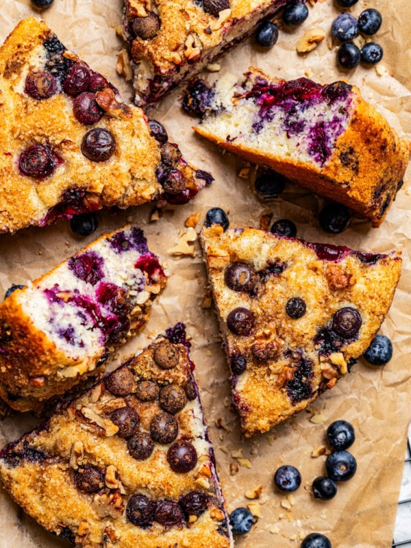 Slices of blueberry cake arranged on brown parchment paper.