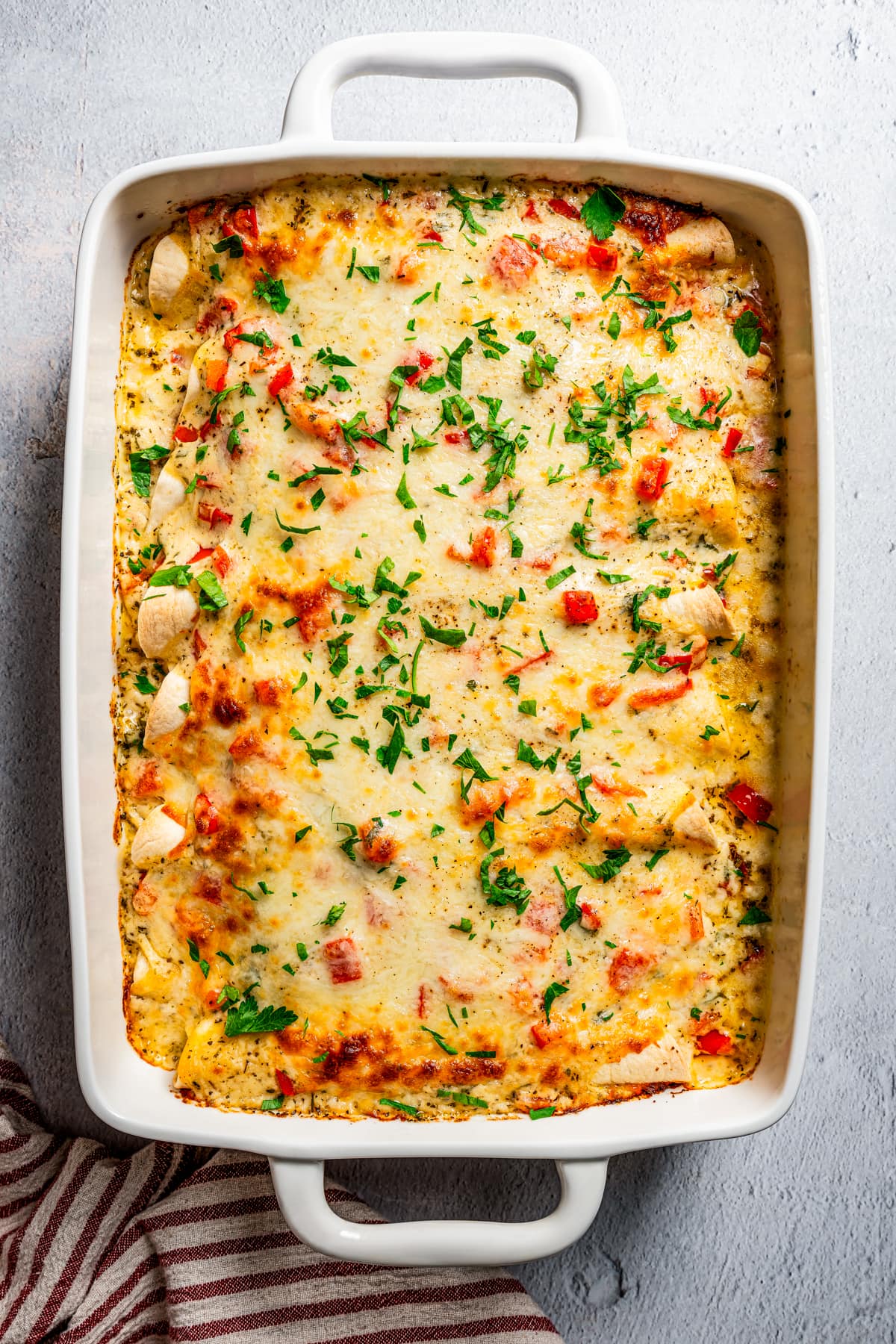 Chicken enchilada casserole in a white casserole dish.