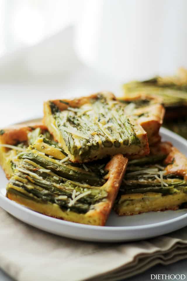 Asparagus frittata cut into squares on a plate.