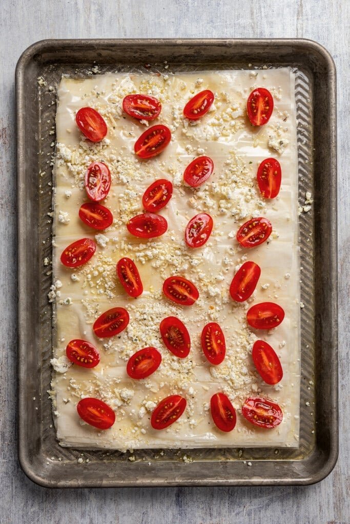 Layered phyllo pastry with cheese and tomatoes on top. 