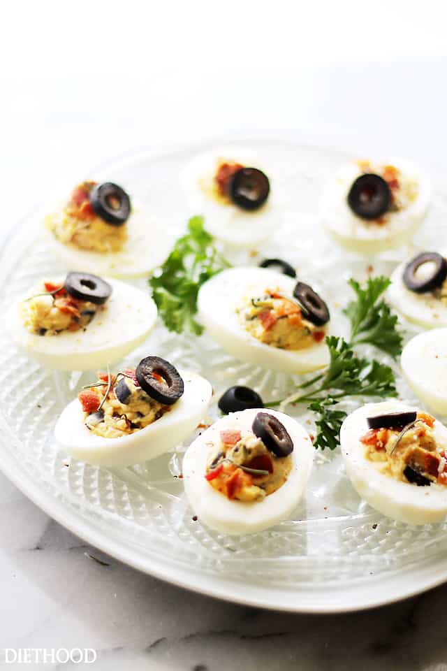 Bacon and Olives Deviled Eggs - The most delicious mixture of egg yolks, olives and bacon with sour cream, chives, and a sprinkle of cajun seasoning. Get the recipe on diethood.com