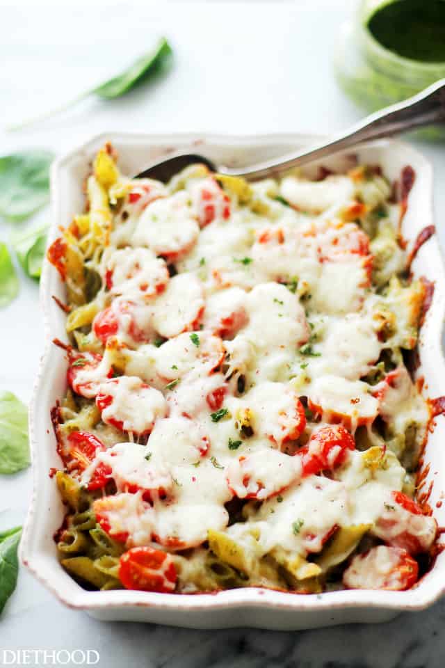 Spinach Pesto Chicken Pasta Bake - A delicious and easy recipe made with chicken, whole wheat pasta and tomatoes tossed in a creamy spinach pesto sauce and topped with cheese. This pasta is a winner every time AND it freezes great, too! Get the recipe on diethood.com