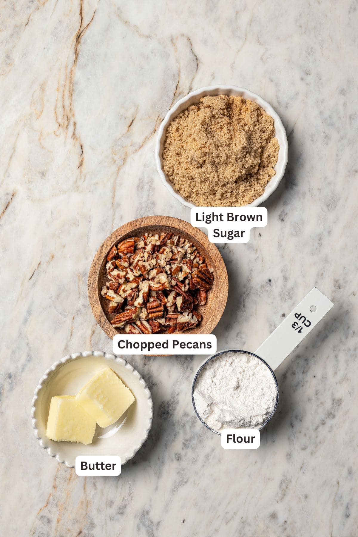 This peach blueberry pie is a fruit-filled custard pie bursting with juicy fresh peaches and blueberries, topped with a nutty pecan streusel. Pecan streusel ingredients with text labels overlaying each ingredient.