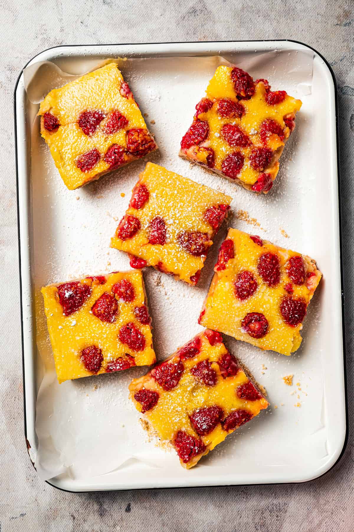 Assorted raspberry lemon bars on a tray.