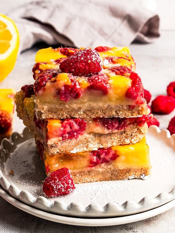 A stack of raspberry lemon bars on a plate by diethood.com