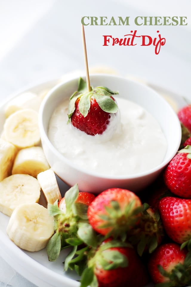 Close-up image of Cream Cheese Fruit Dip served in a bowl with bananas and strawberries arranged around the bowl.