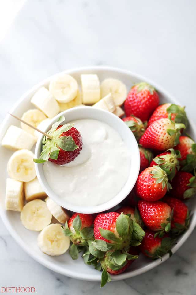 Cream Cheese Fruit Dip served in a bowl with bananas and strawberries arranged around the bowl.