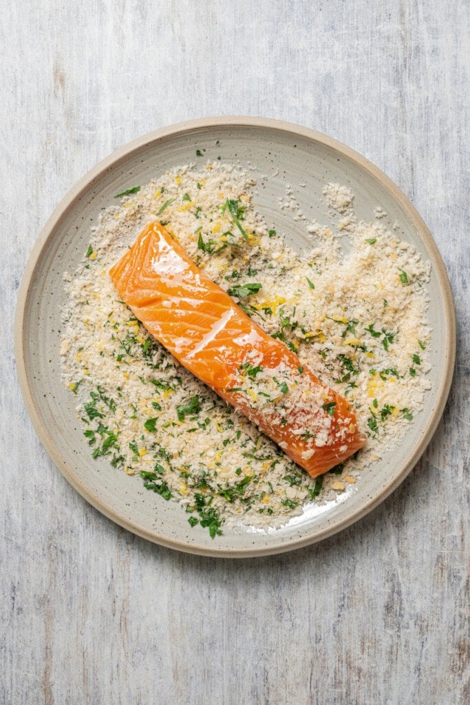 A salmon filet placed into the panko crumb topping.