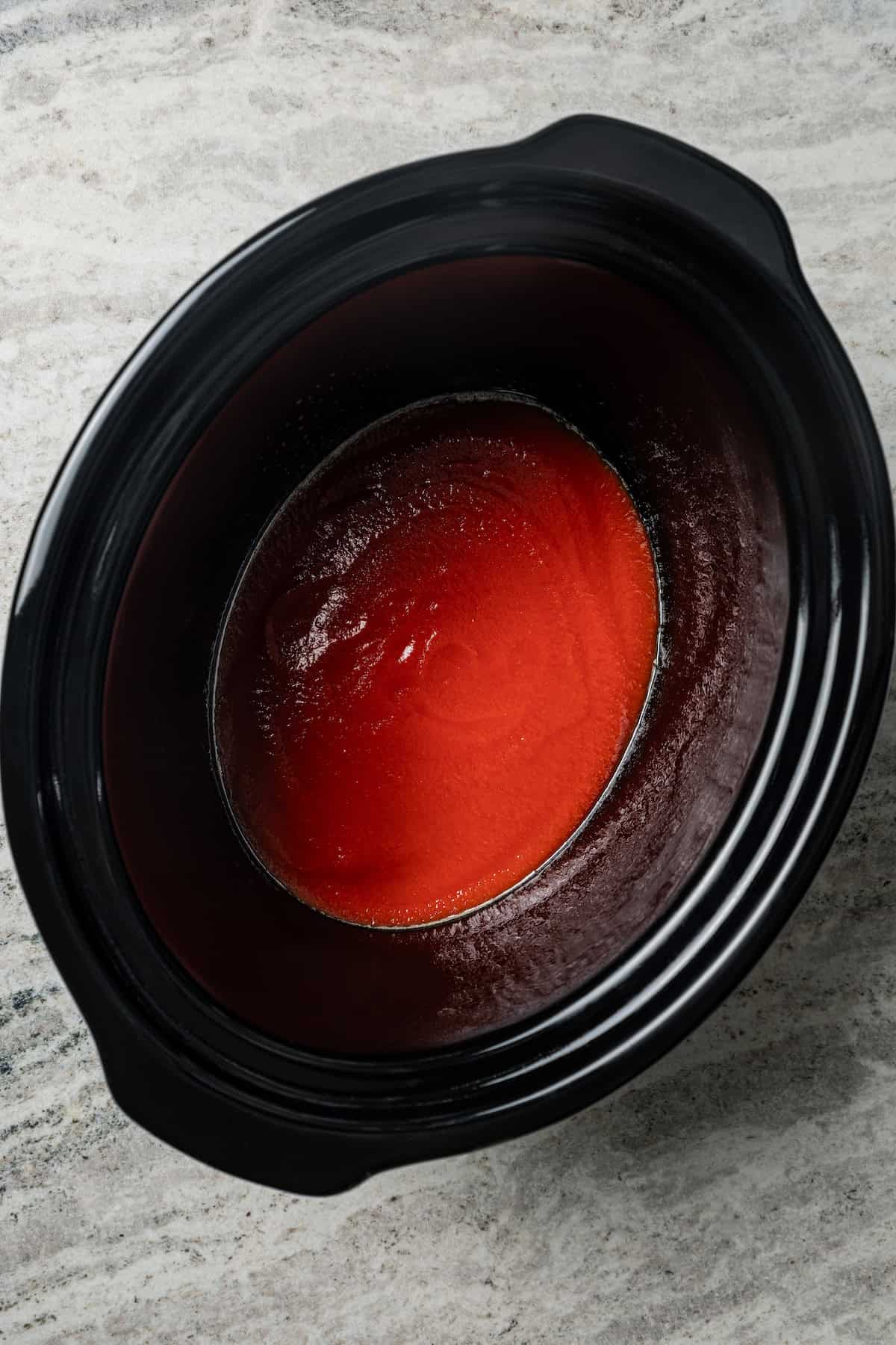 Marinara sauce in the bottom of the crock pot.