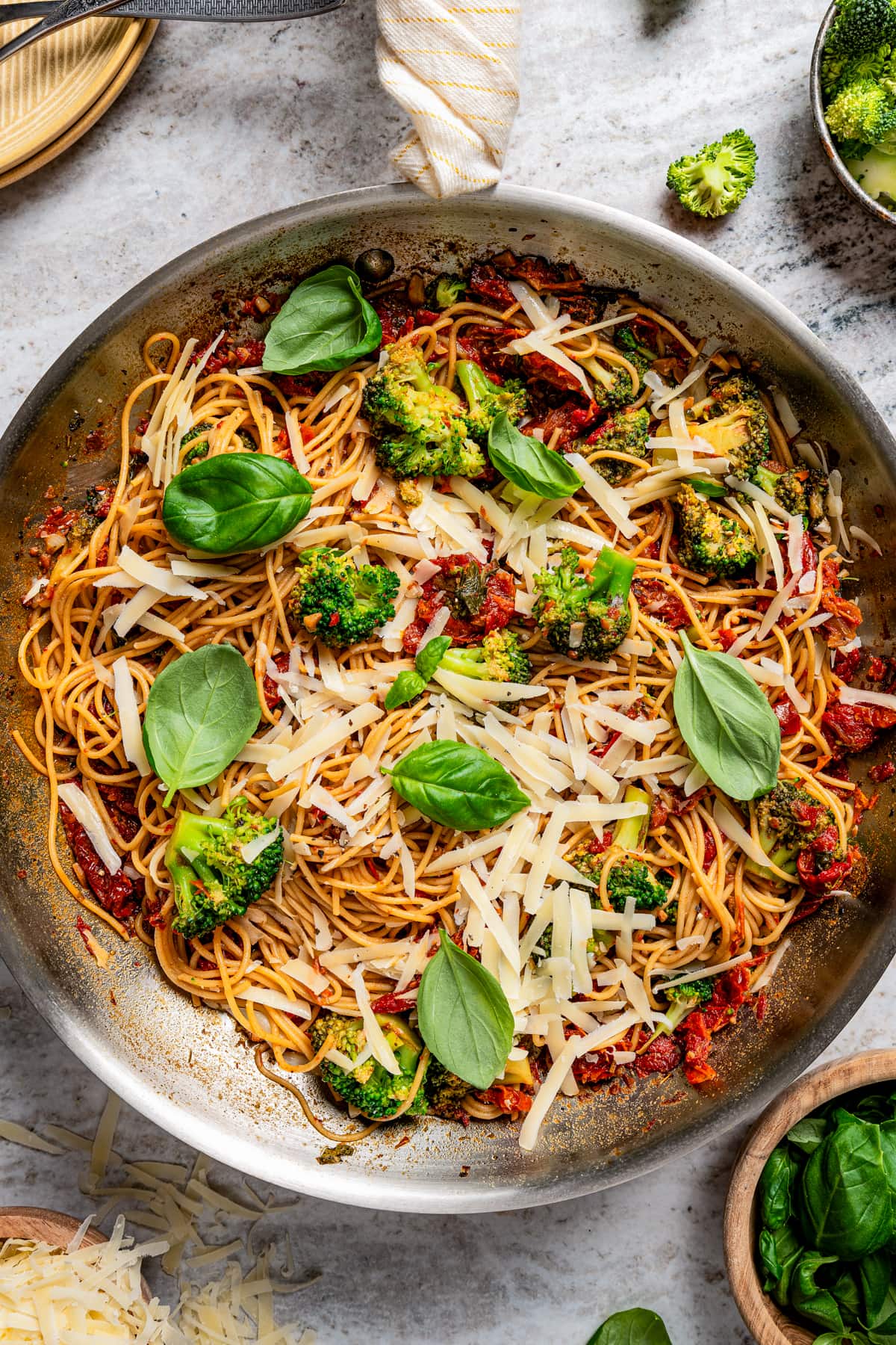Pan with sun-dried tomatoes tossed with pasta, parmesan cheese, and fresh basil.