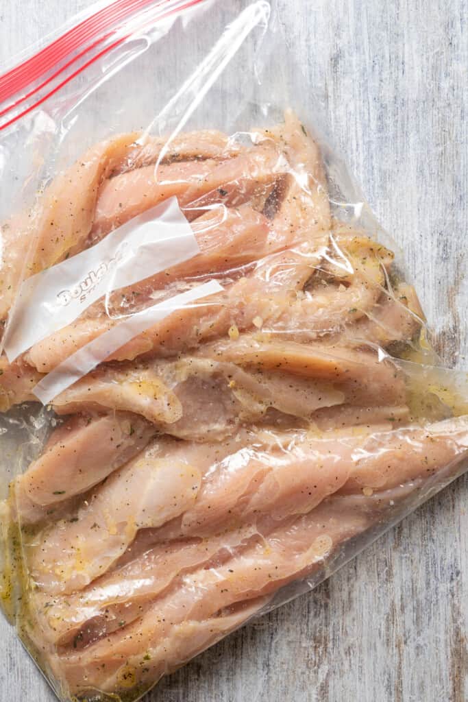 Marinating chicken in a plastic ziploc bag.