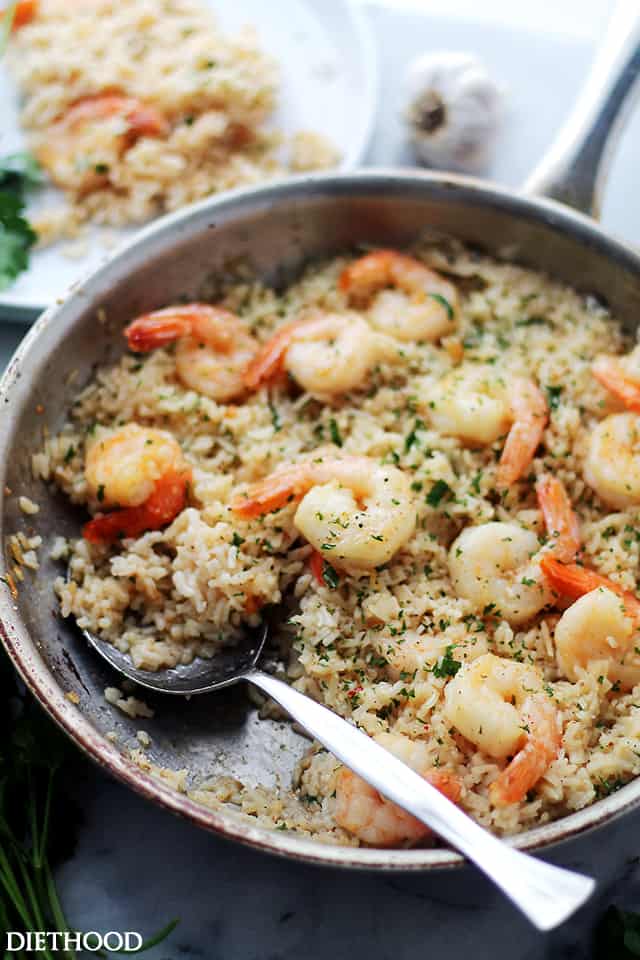 Side shot of cooked rice with cooked shrimp arranged on top.