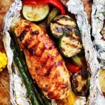 Grilled Barbecue Chicken and Vegetables in Foil - Tender, flavorful chicken covered in sweet barbecue sauce and cooked on the grill inside foil packs with zucchini, bell peppers and asparagus.