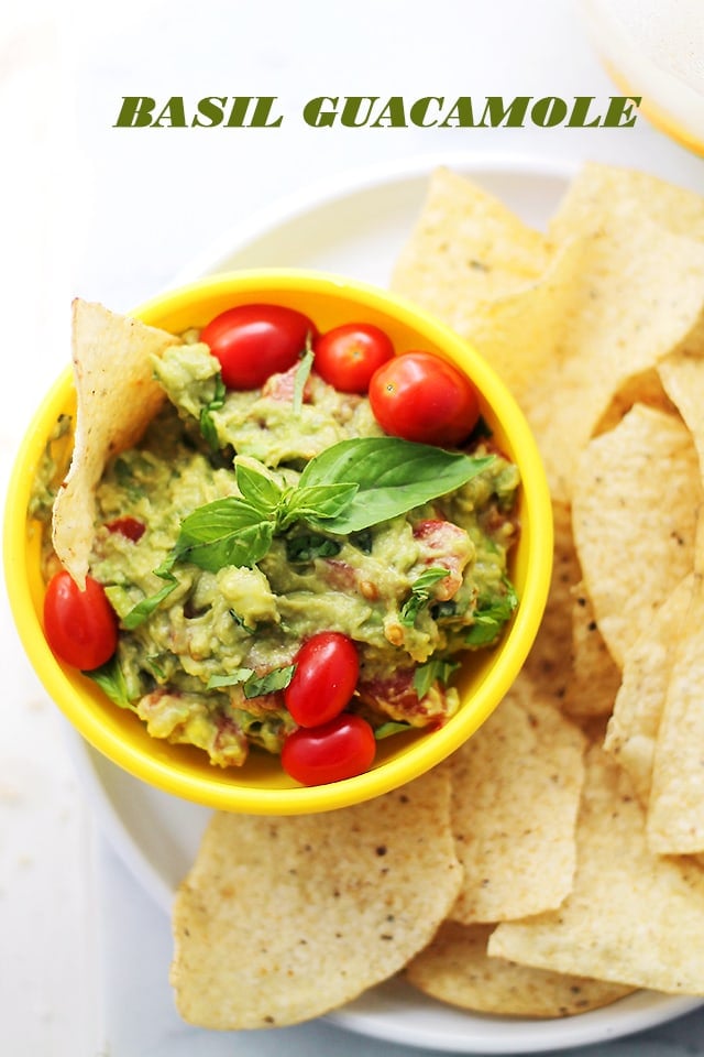 Basil Guacamole served in a small yellow bowl with tortilla chips
