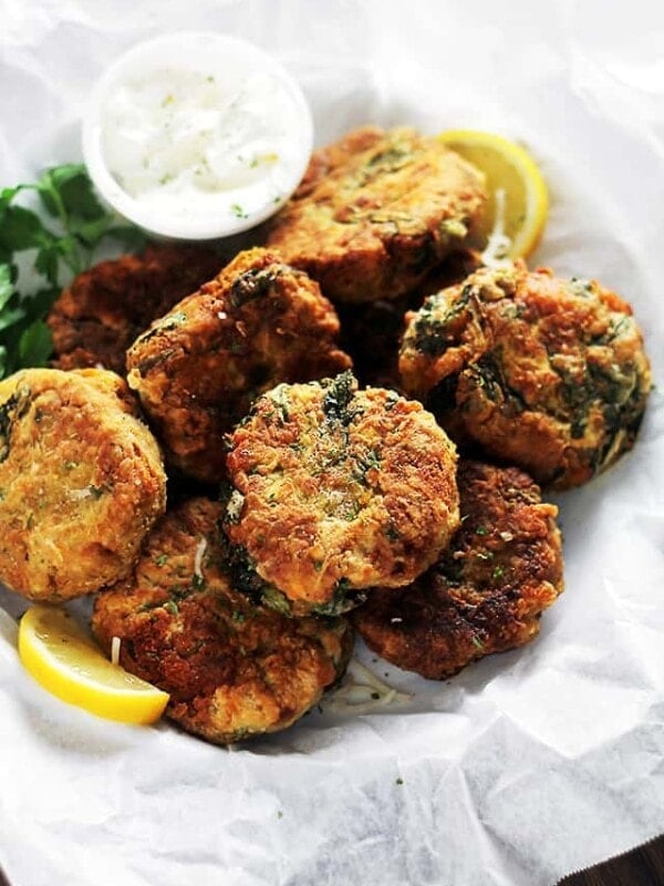 Lentil fritters served in a lined basket with a side of dipping sauce.