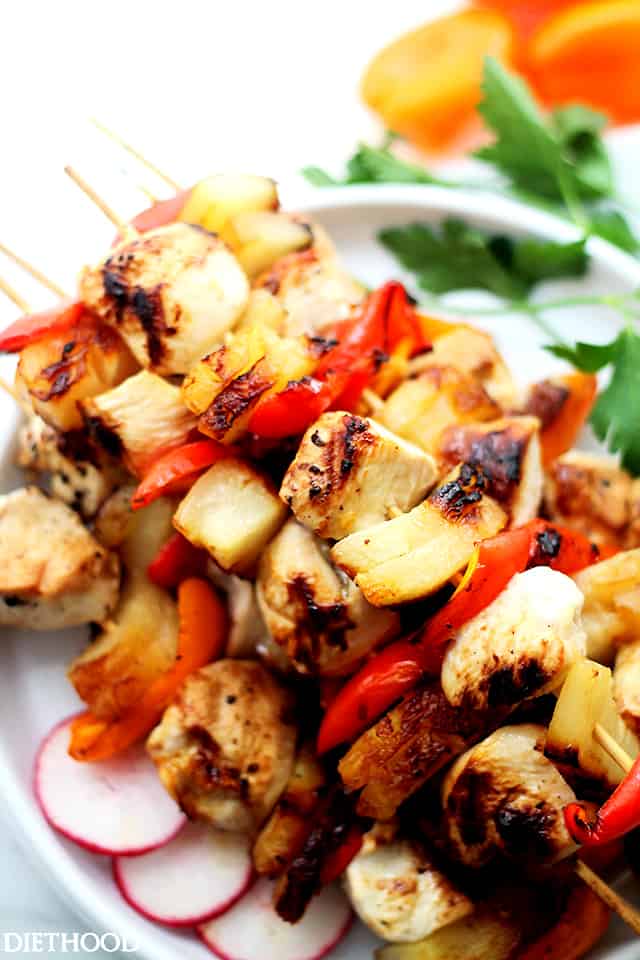 Grilled chicken pineapple kabobs stacked on a plate.