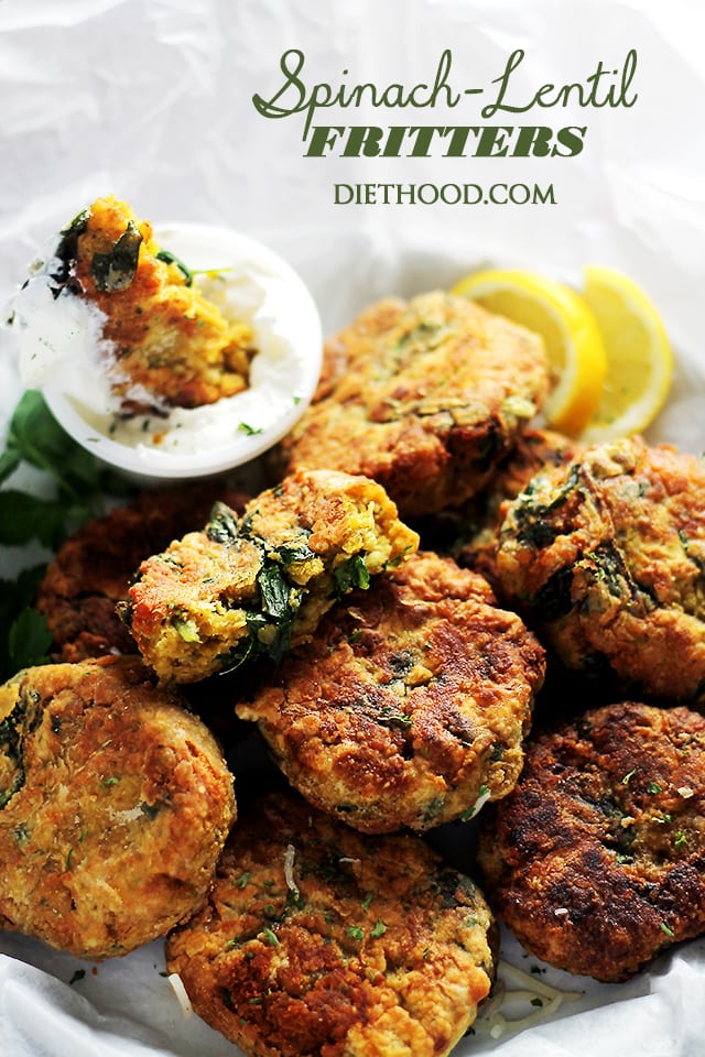 Spinach Lentil Fritters served in a plate with lemon slices and yogurt dip