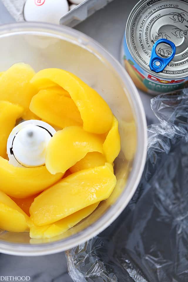 Sliced mangoes inside of a food processor.