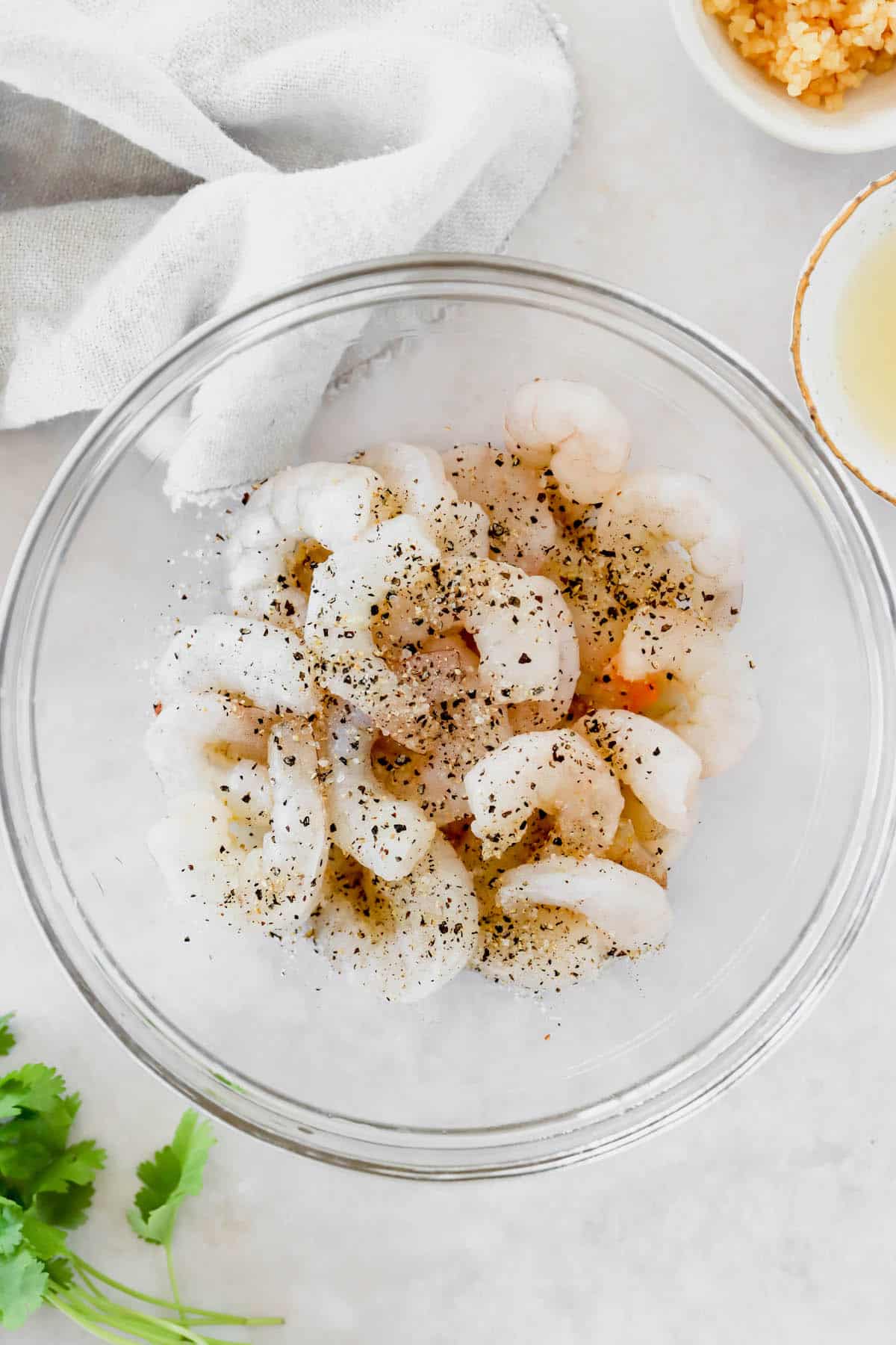 Raw shrimp with salt and pepper in a mixing bowl