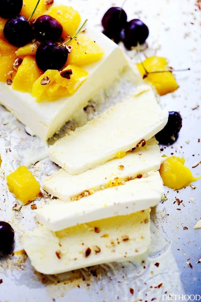 Four slices of mango semifreddo with the remaining semifreddo beside them.