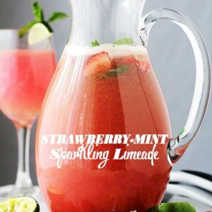 Strawberry limeade in a pitcher with a glass of strawberry limeade behind it.