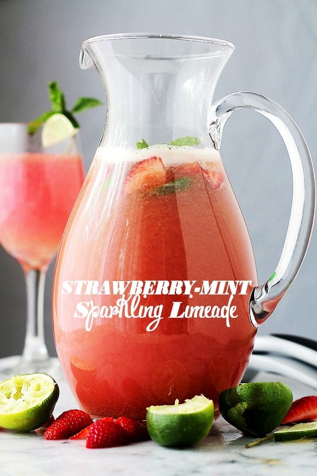 Strawberry limeade in a pitcher with a glass of strawberry limeade behind it.