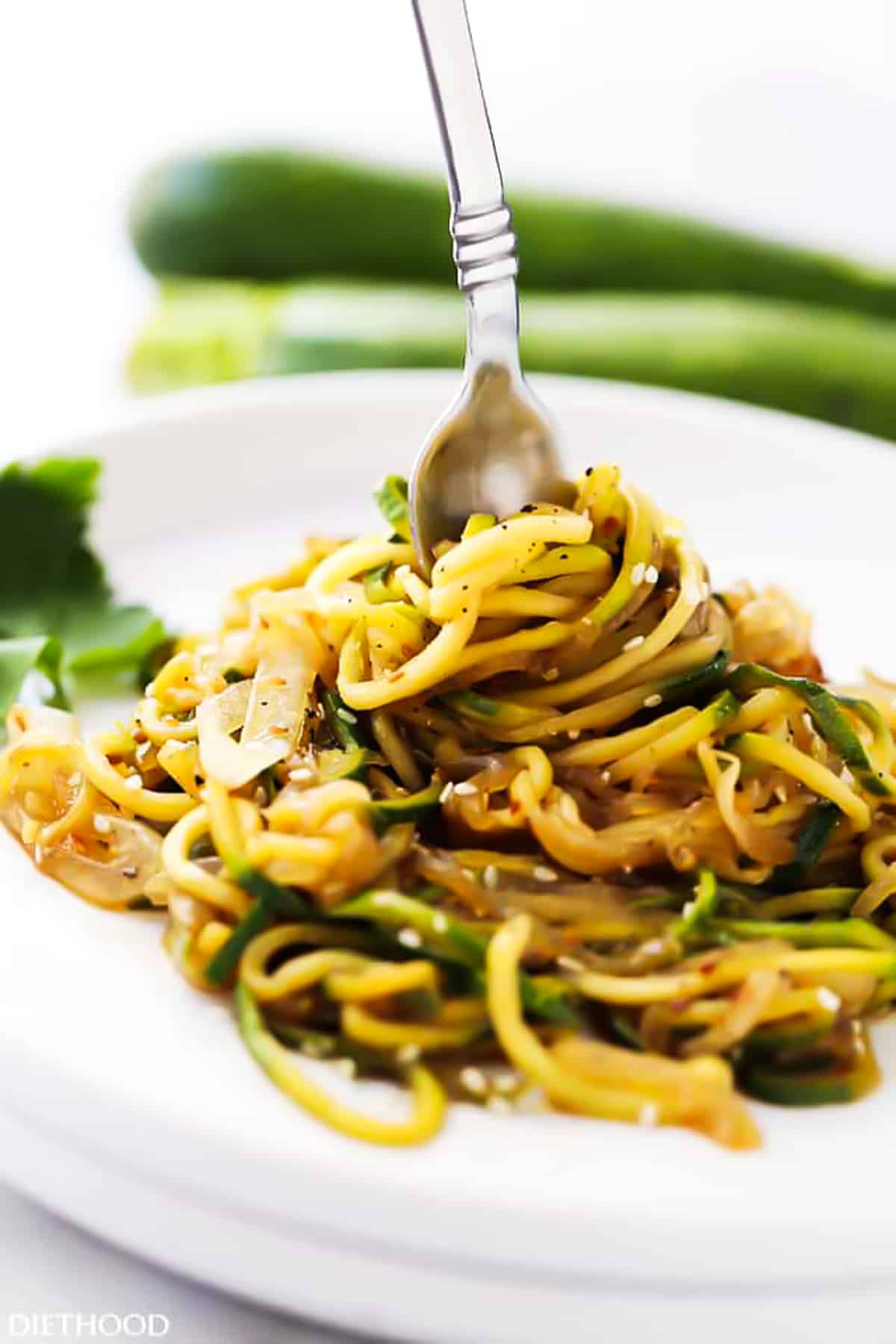 sticking a fork over a bunched cooked zoodles.