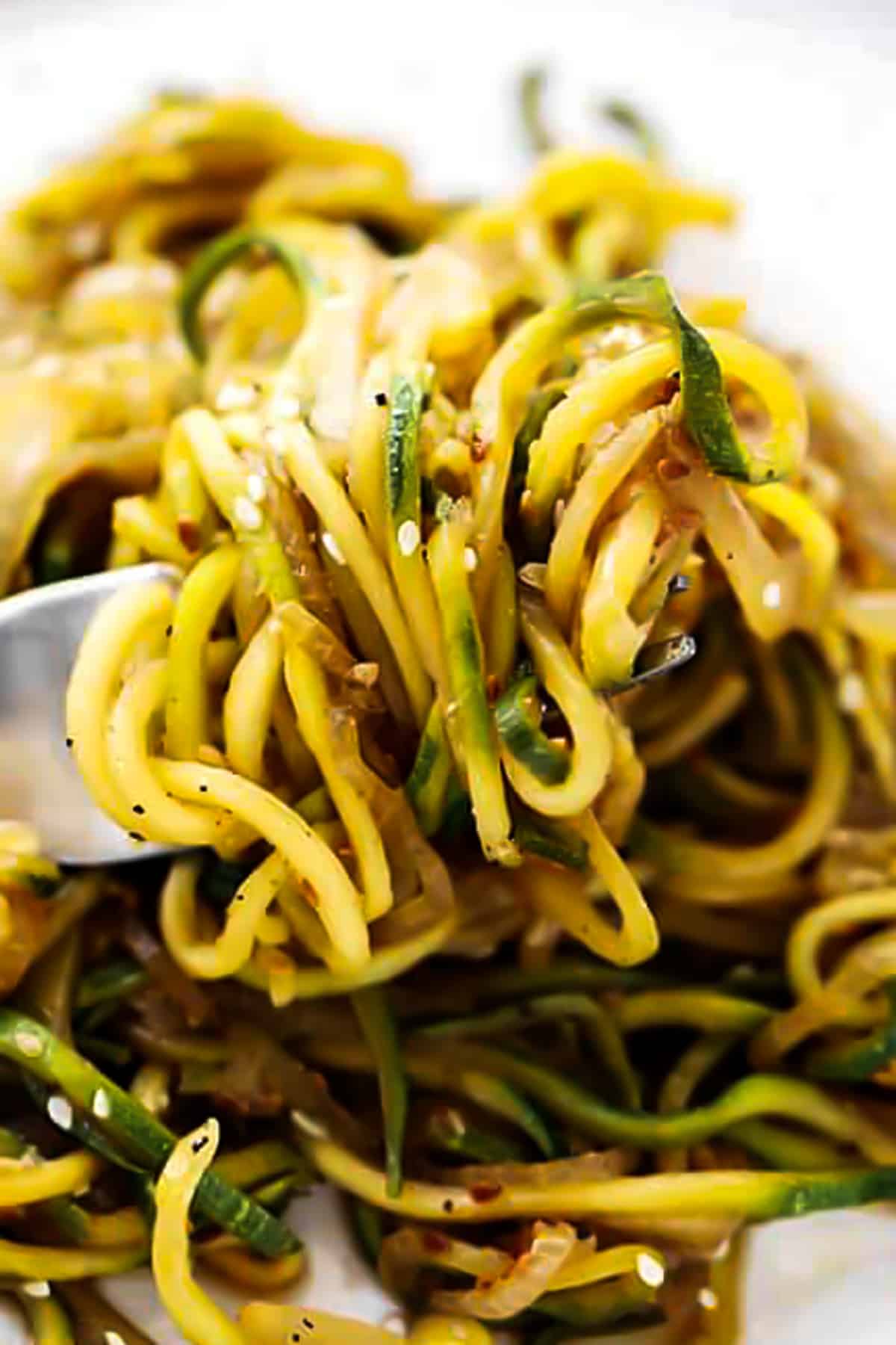 a fork holding up spiralized zucchini.