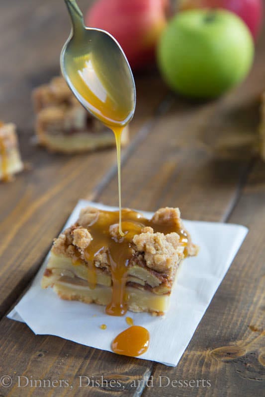 Caramel apple pie bar with caramel drizzle on a piece of parchment paper