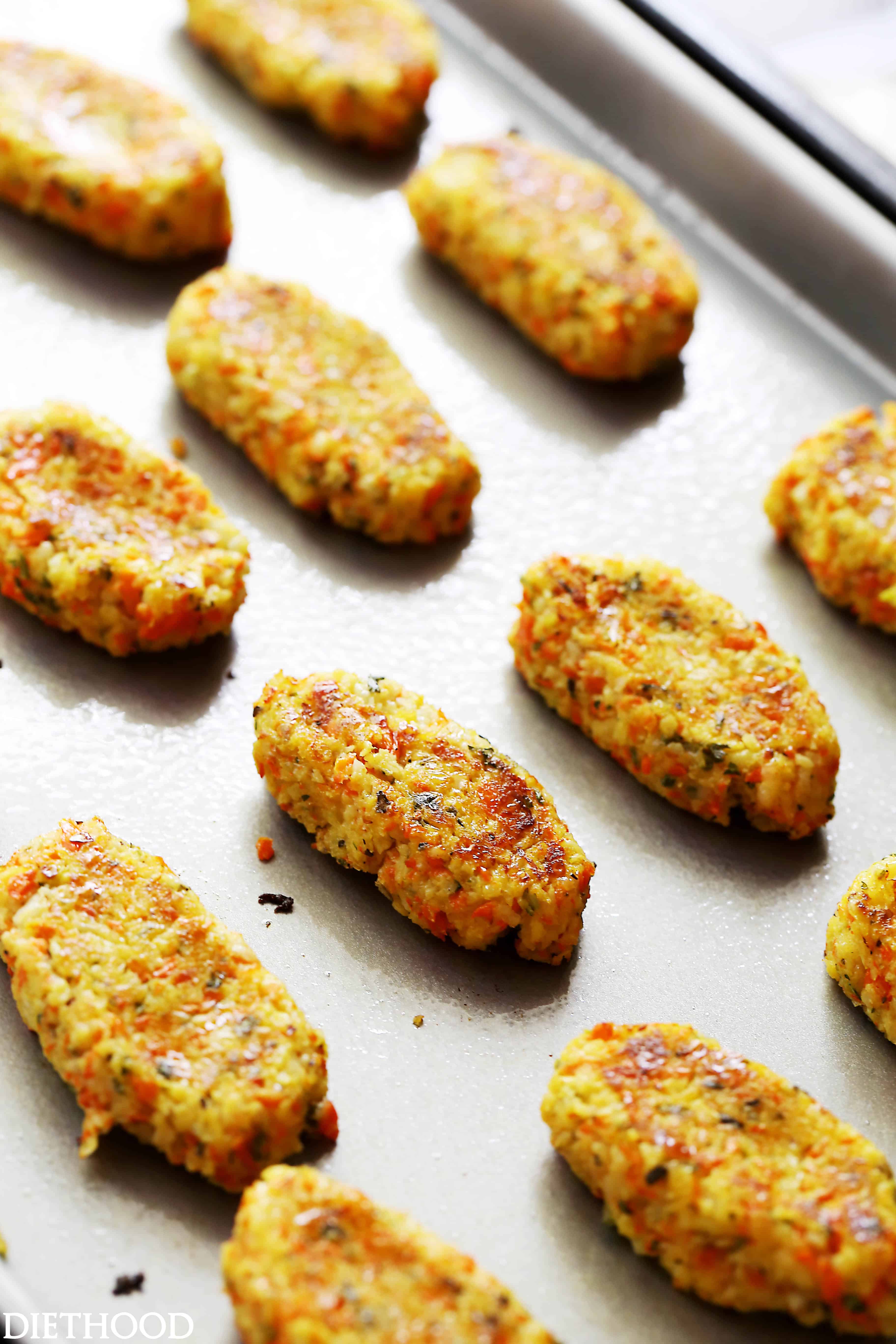 These cauliflower tots are low-carb, kid-friendly, and delicious! They're made with veggies, egg, breadcrumbs, and cheese, baked in the oven. Rows of homemade cauliflower tots on a baking sheet.
