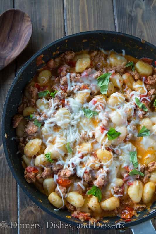 Gnocchi and Sausage with melted cheese in a skillet