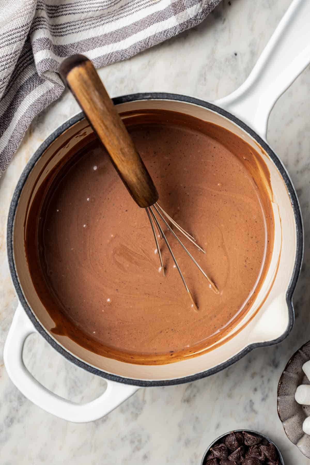 Dark hot chocolate in a large pot with a whisk.