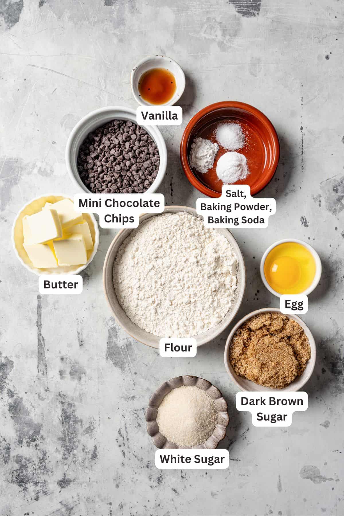 Ingredients for mini chocolate chip cookies with text labels overlaying each ingredient.