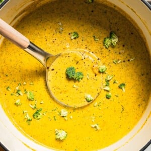Overhead image of broccoli cheese soup in a soup pot with a ladle.